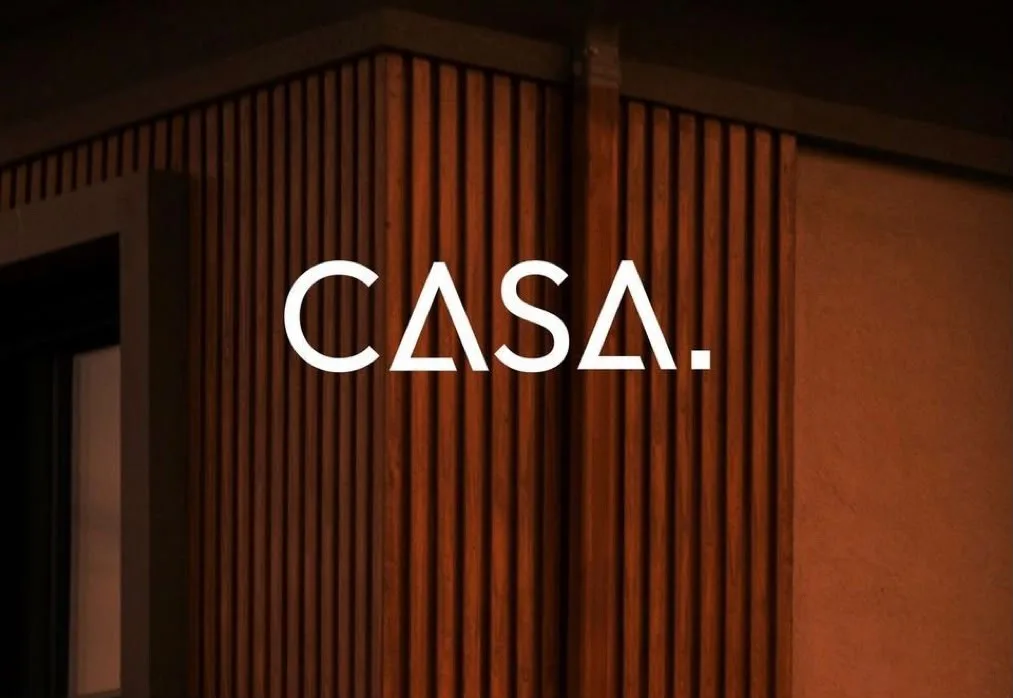 La fachada de CASA. — listones de madera y luz cálida